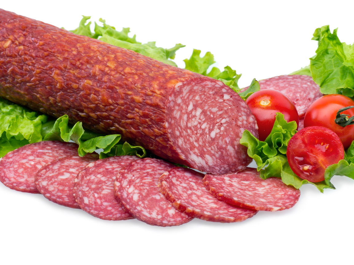 Колбаса с помидорами и зелеными листьями салата на белом фоне