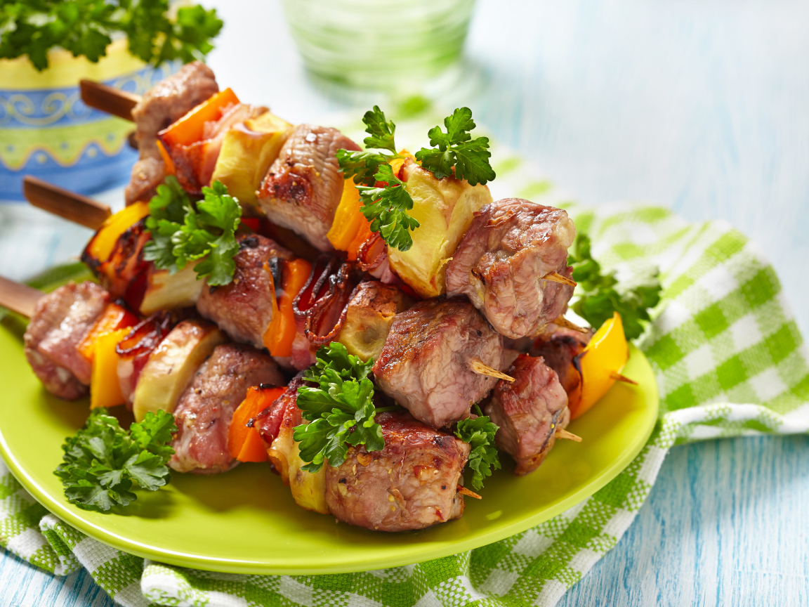 Шашлык с овощами на тарелке на столе