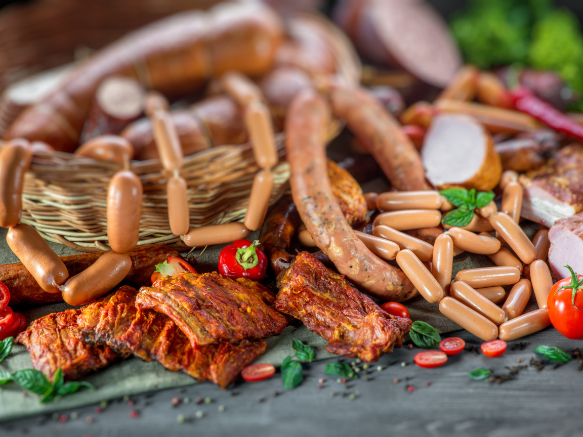 Копченые ребрышки с колбасой на столе 