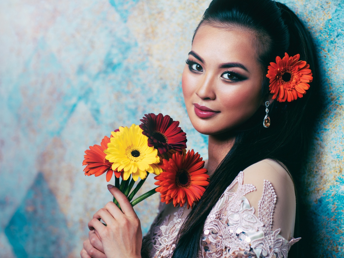 Красивая девушка азиатка с букетом гербер в руках