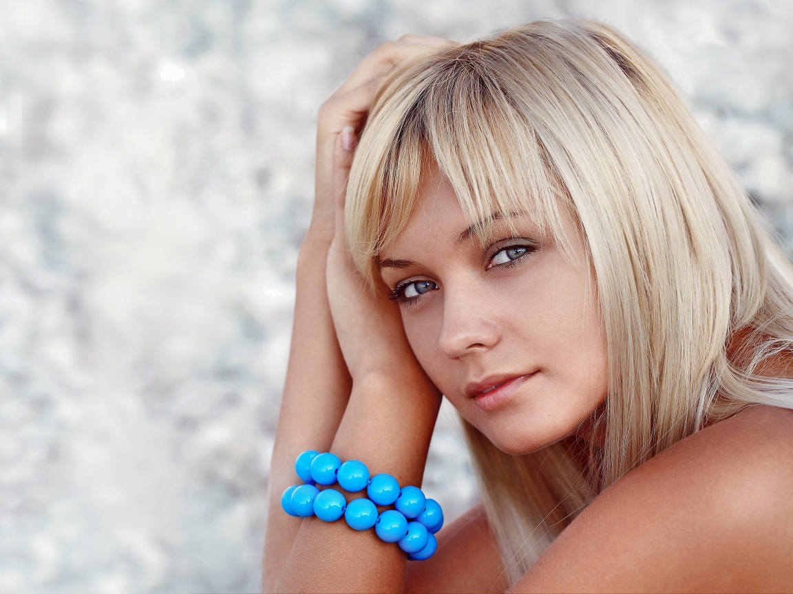 Красивая блондинка с большим голубым браслетом на руке