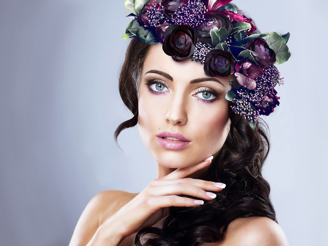 Красивая голубоглазая девушка с венком на голове на сером фоне