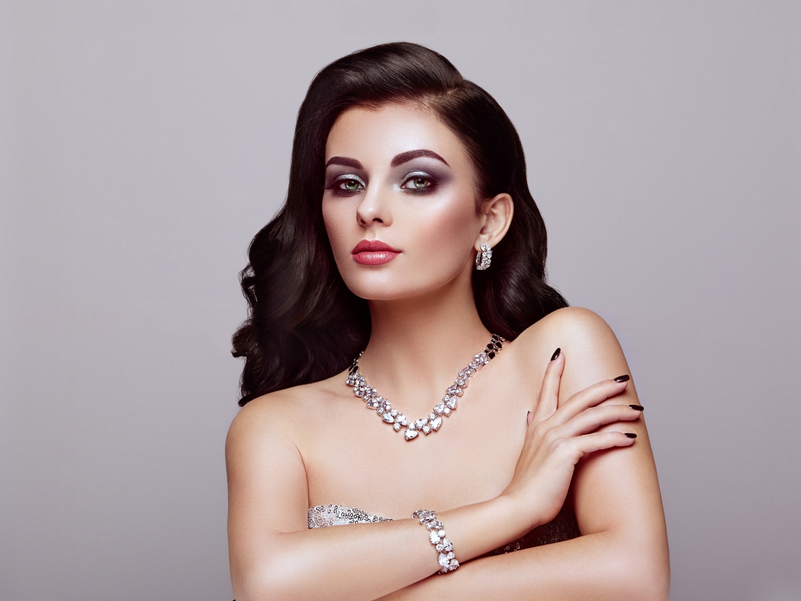 Красивая яркая брюнетка на сером фоне