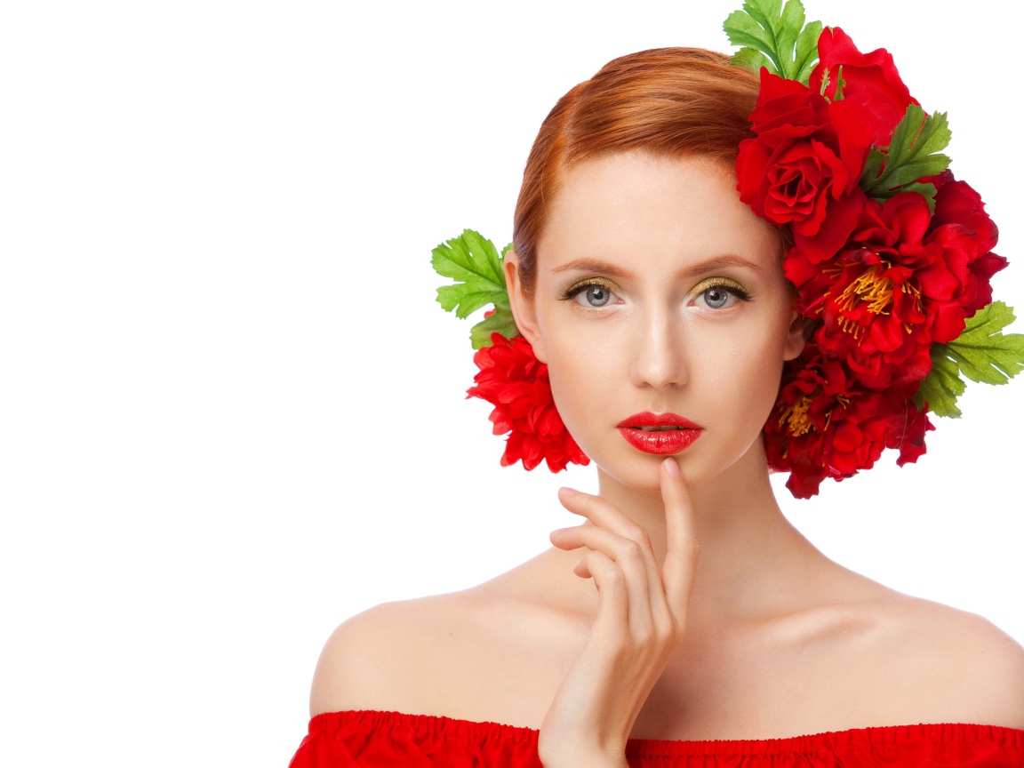 Красивая яркая девушка с красными цветами в волосах на белом фоне