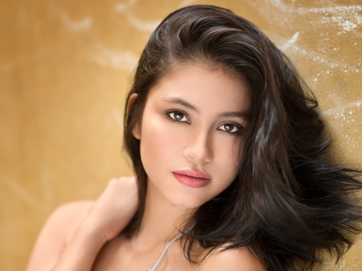 Красивая брюнетка на фоне стены 