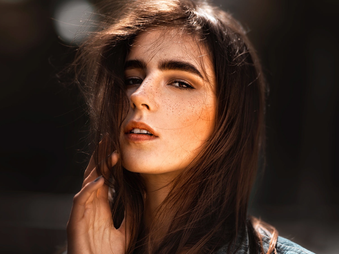 Красивая брюнетка с веснушками на лице