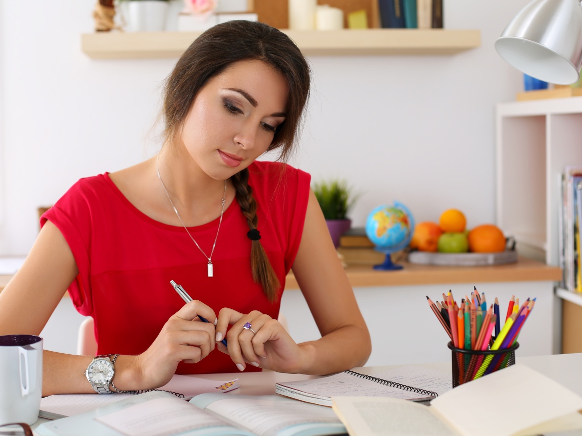 Красивая деловая девушка за столом с тетрадями