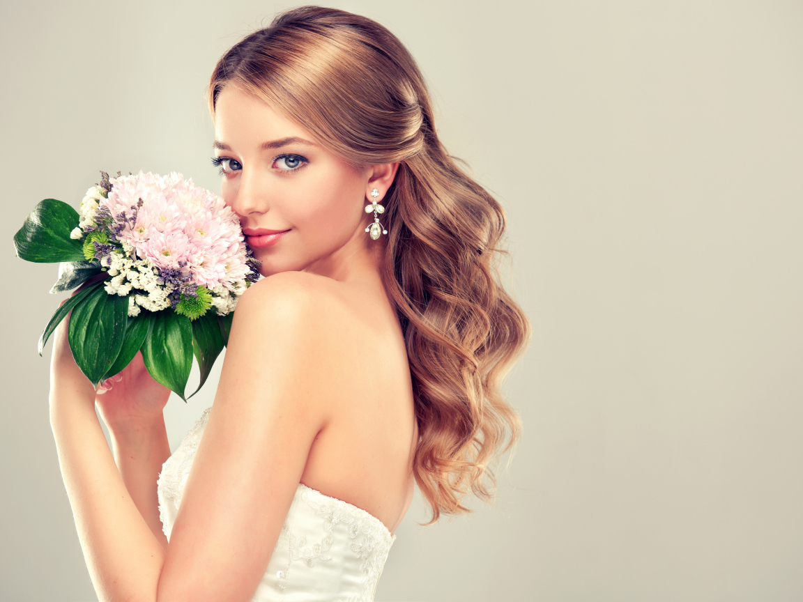 Красивая девушка невеста с букетом цветов на сером фоне