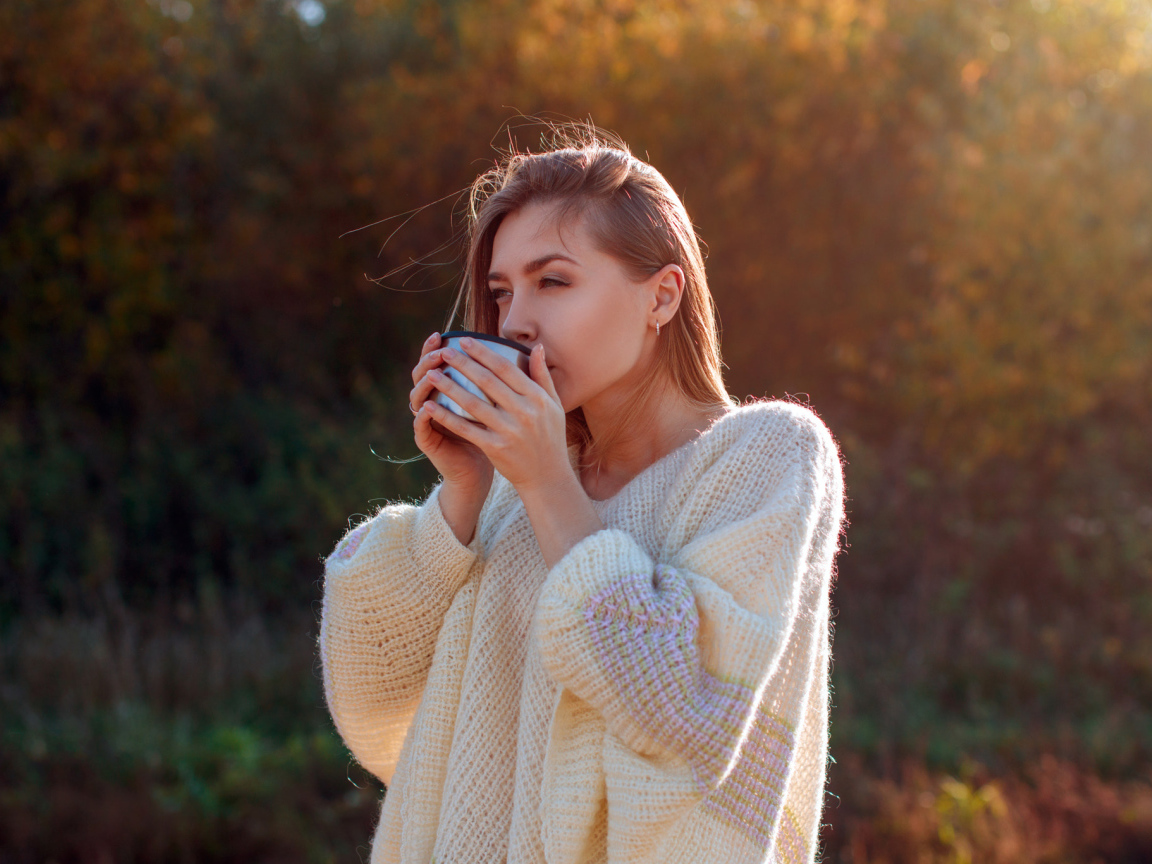 Красивая девушка пьет чай в теплом свитере