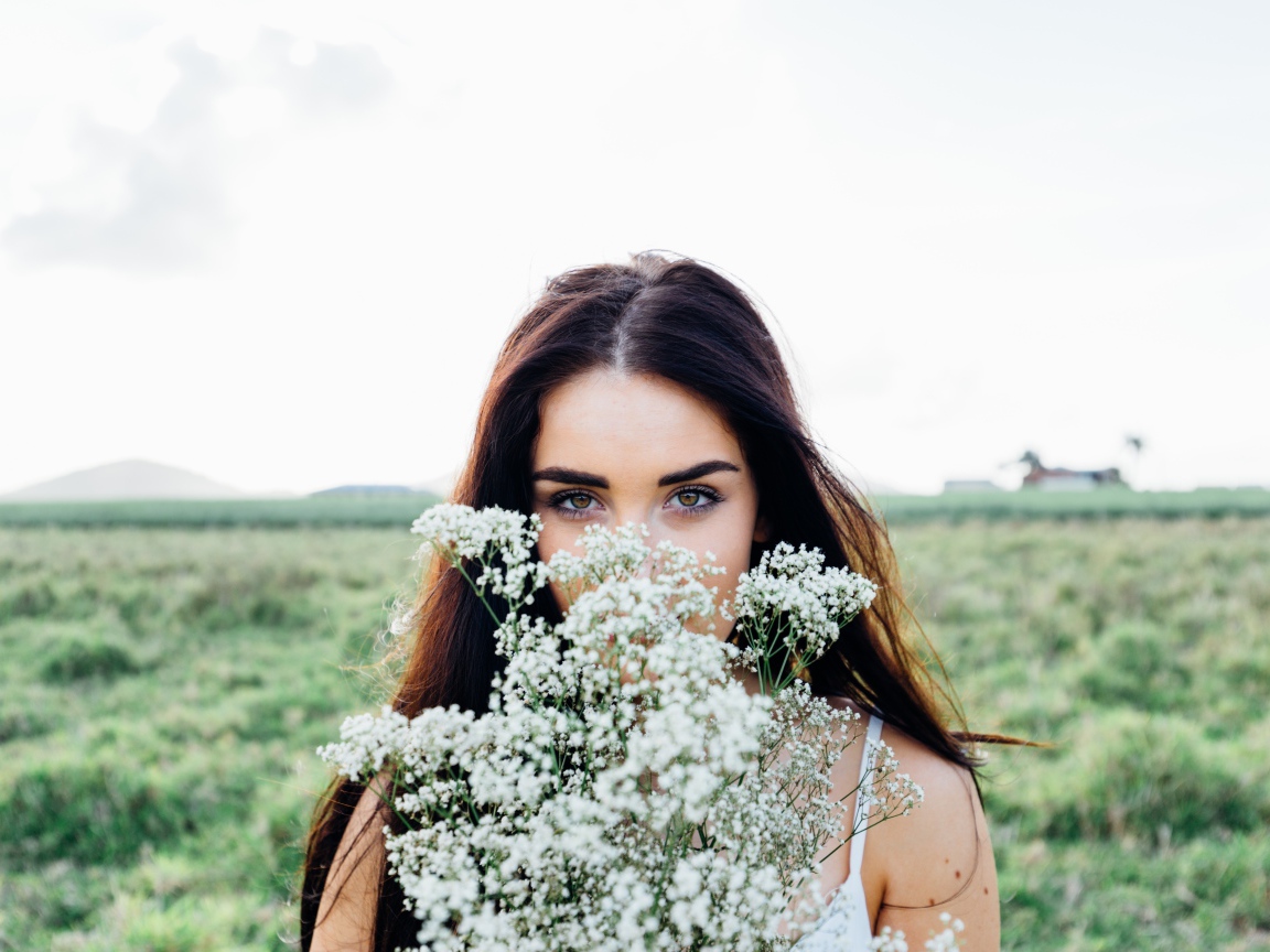 Красивая девушка с букетом полевых цветов