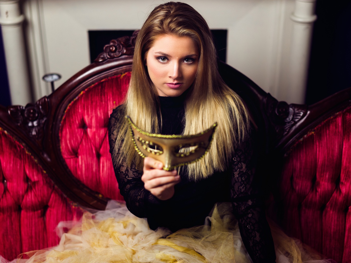 Красивая девушка с маской в руках