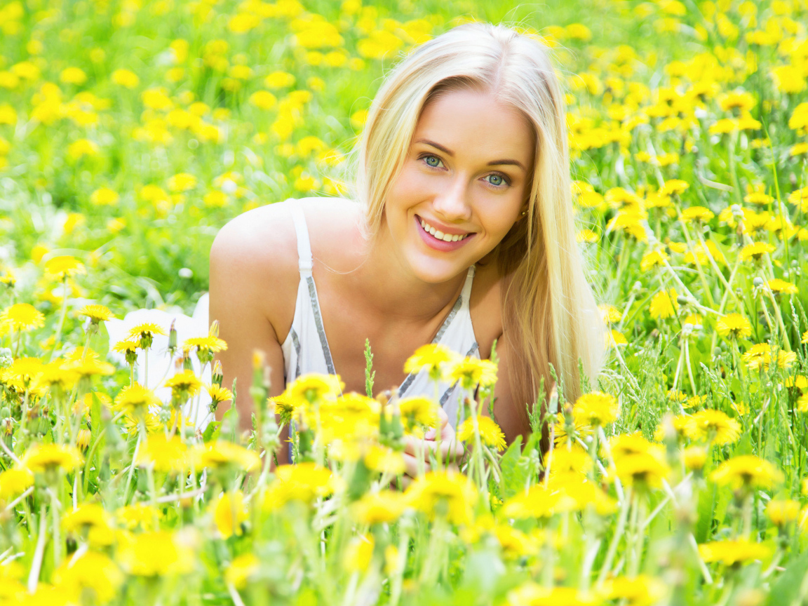 Красивая улыбающаяся блондинка в желтых одуванчиках