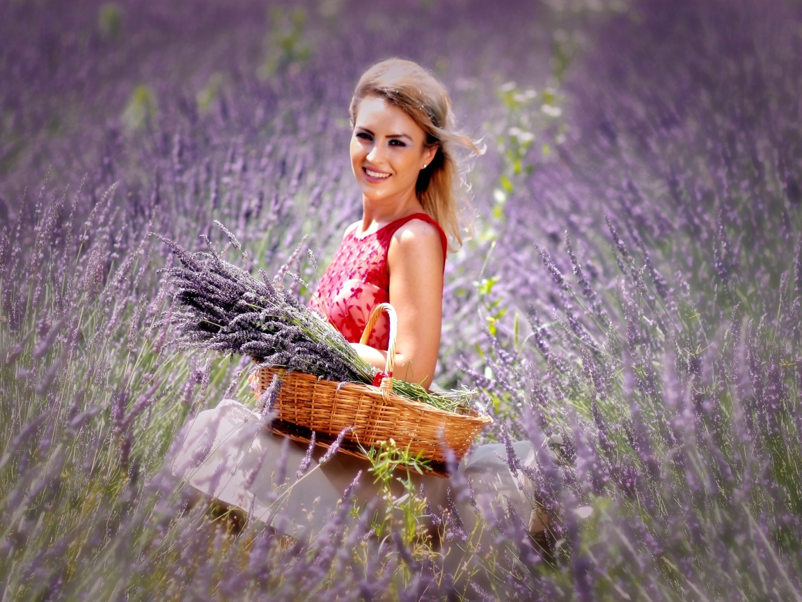 Красивая улыбающаяся девушка с корзиной на лавандовом поле