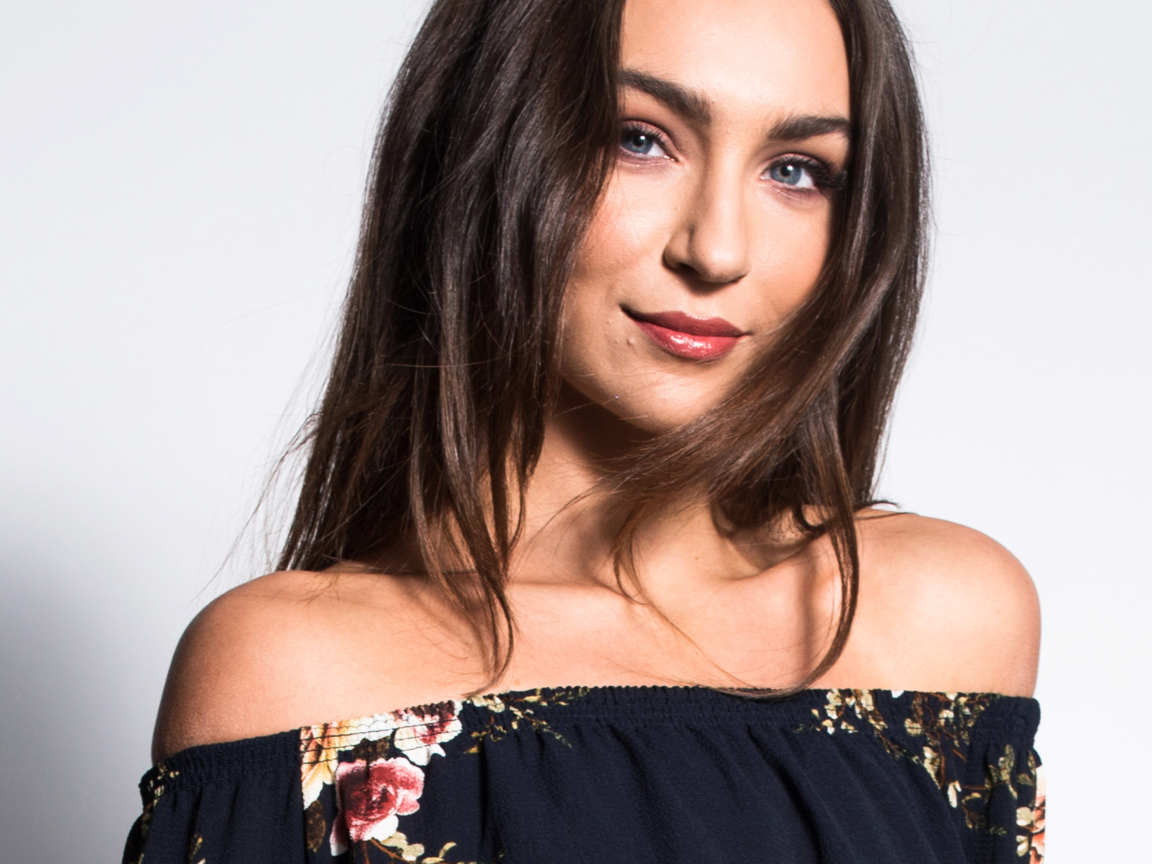 Красивая нежная голубоглазая брюнетка на сером фоне