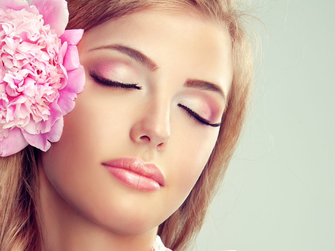 Красивая нежная молодая девушка с розовым цветком пиона в волосах 