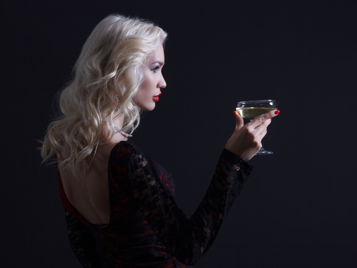 Блондинка с бокалом мартини в руках сером фоне 