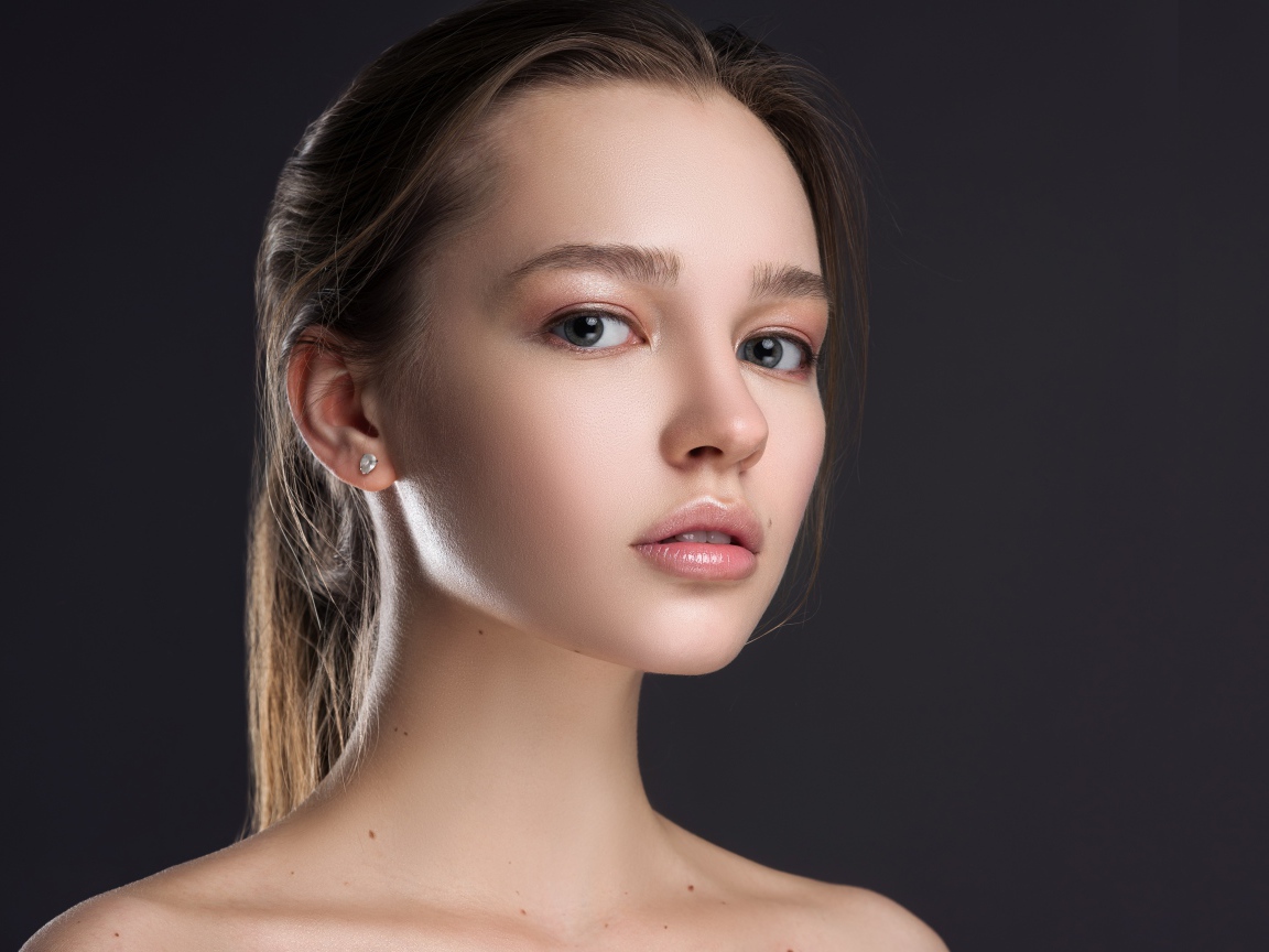 Нежная настоящая девушка шатенка на сером фоне