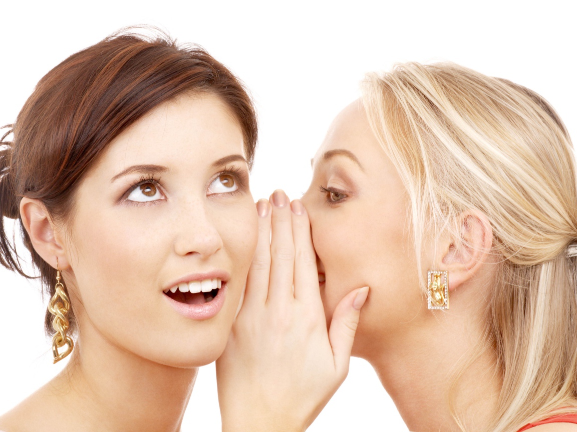 Две подруги делятся секретами на белом фоне 