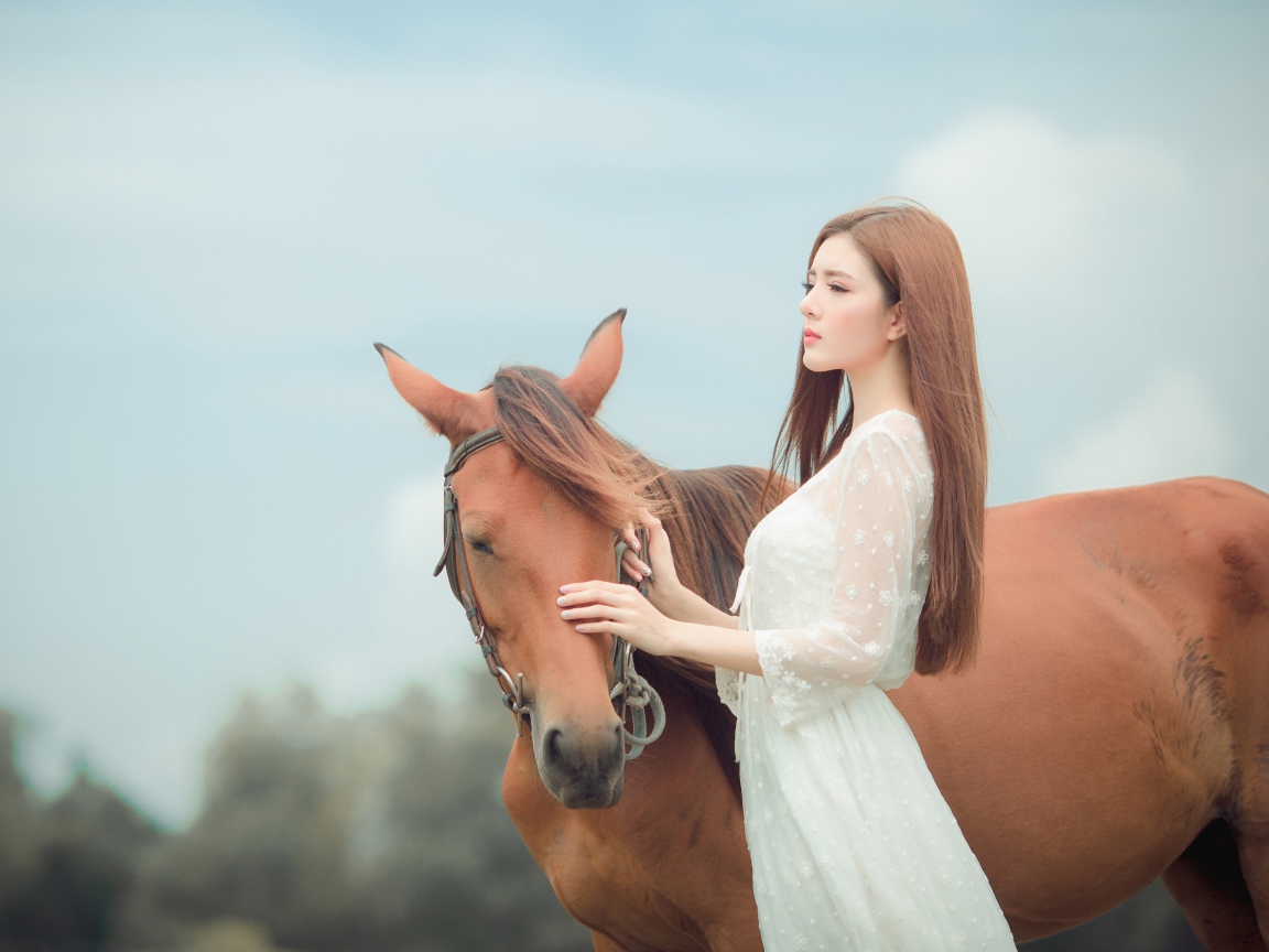 Молодая азиатка в белом платье с лошадью 