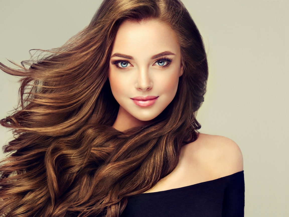 Молодая голубоглазая девушка с красивыми длинными волосами