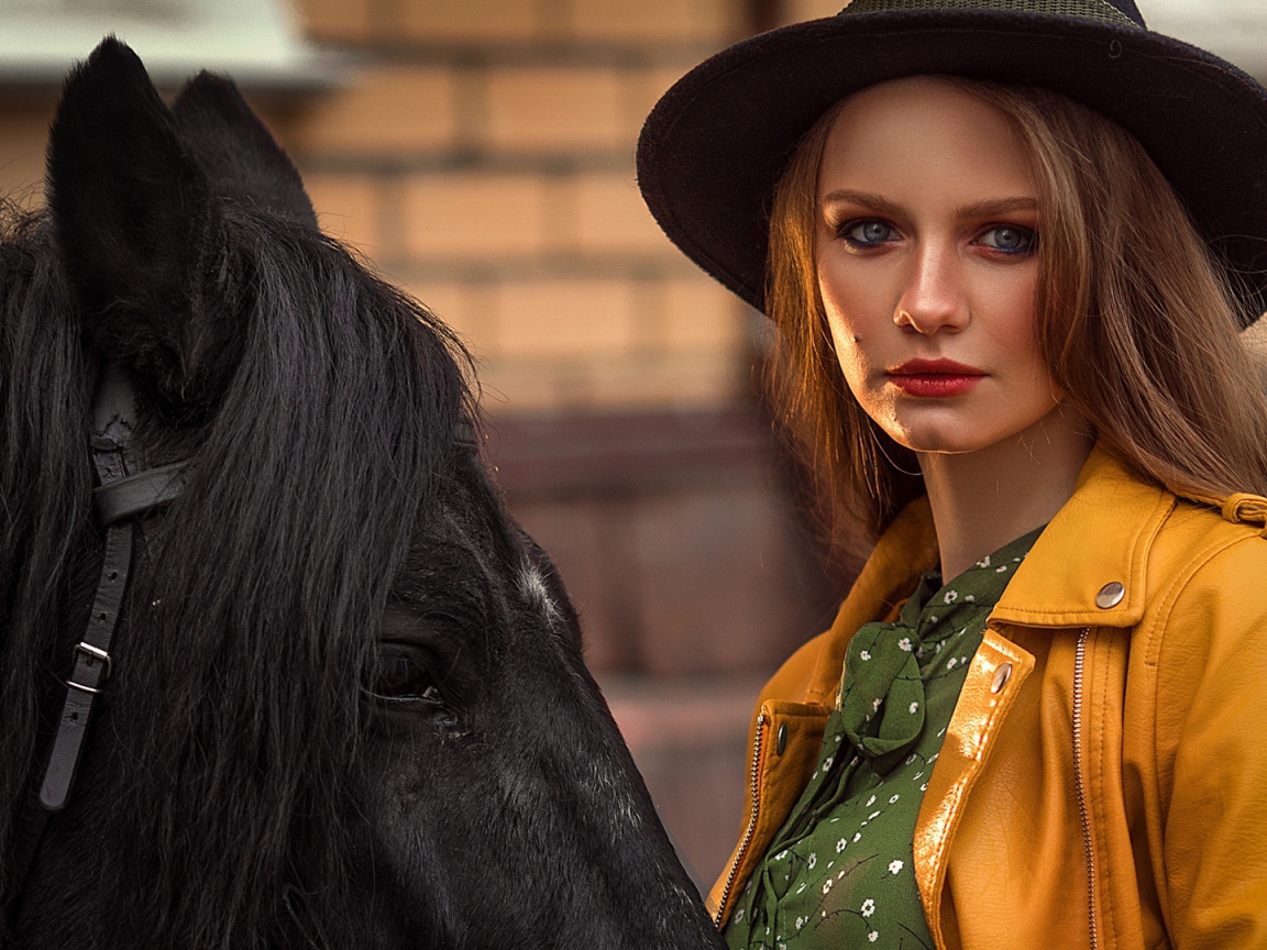 Молодая девушка в черной шляпе с конем 