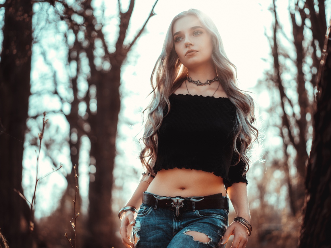 Молодая девушка в рваных джинсах с пирсингом в носу