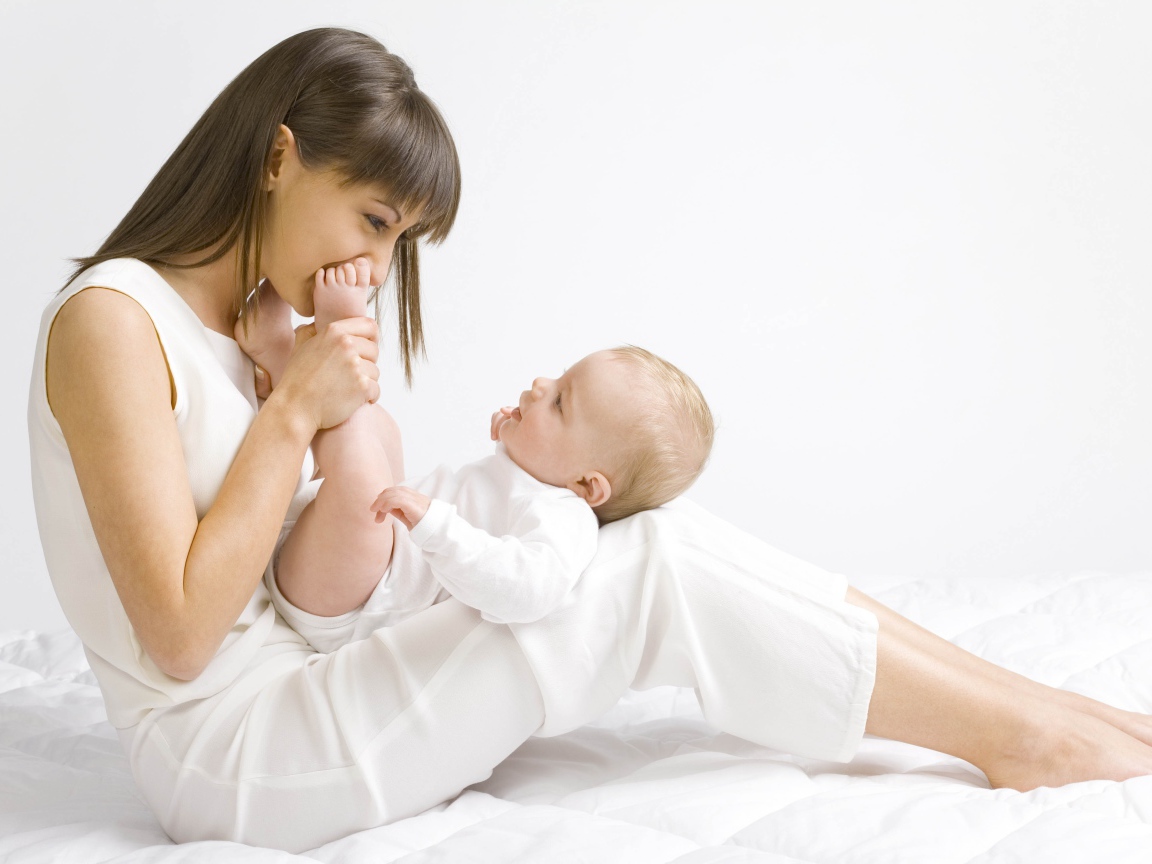 Молодая девушка в белом с младенцем