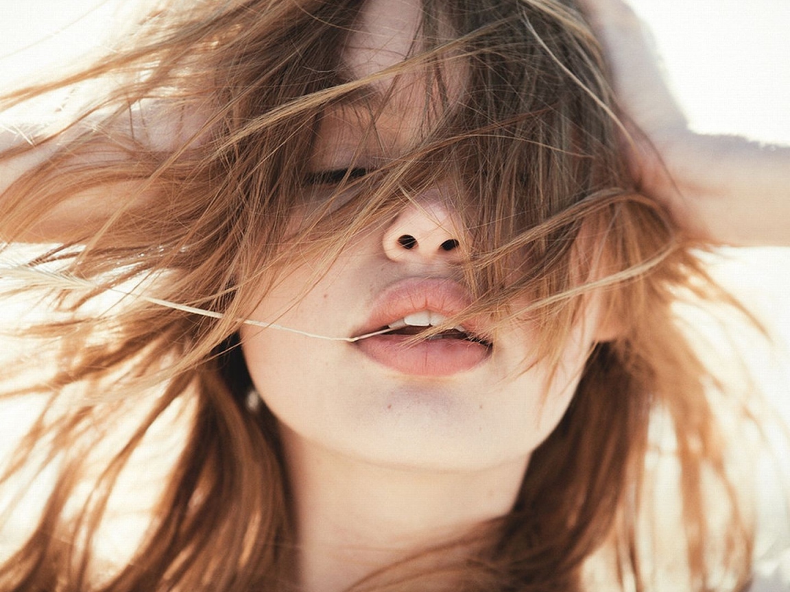 Молодая девушка с распущенными волосами на ветру