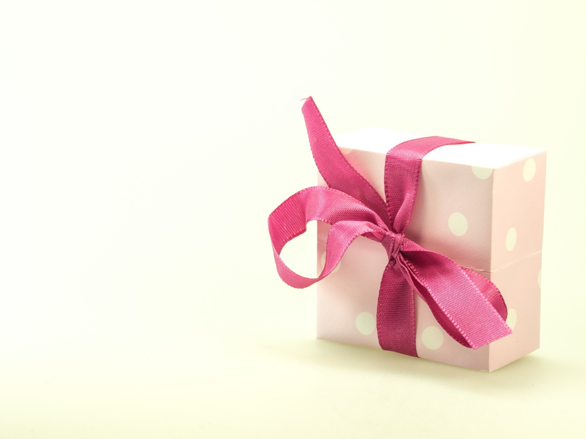 Подарочная коробка с розовым бантом на белом фоне