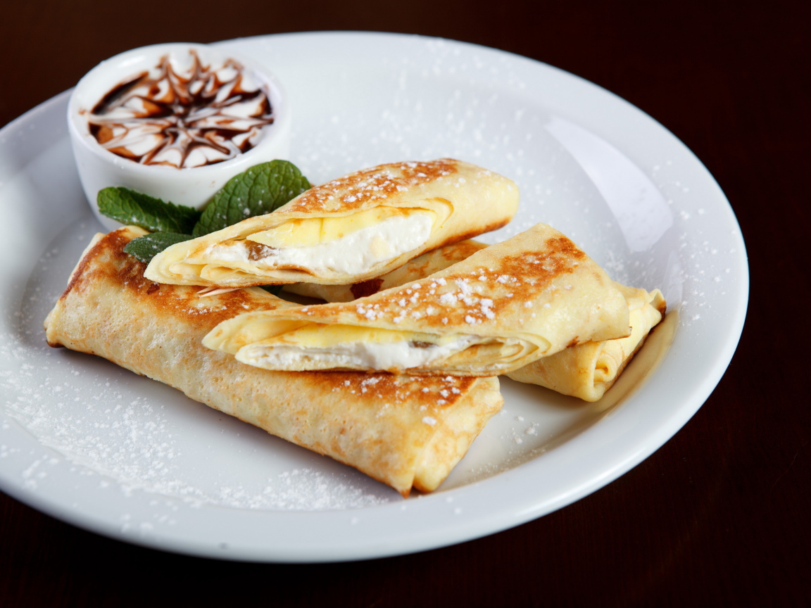 Блины с творогом и сметаной на белой тарелке на Масленицу