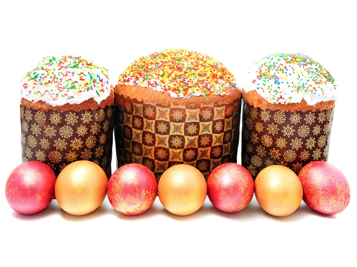 Три пасхальных кулича с крашеными яйцами на белом фоне на праздник Пасха