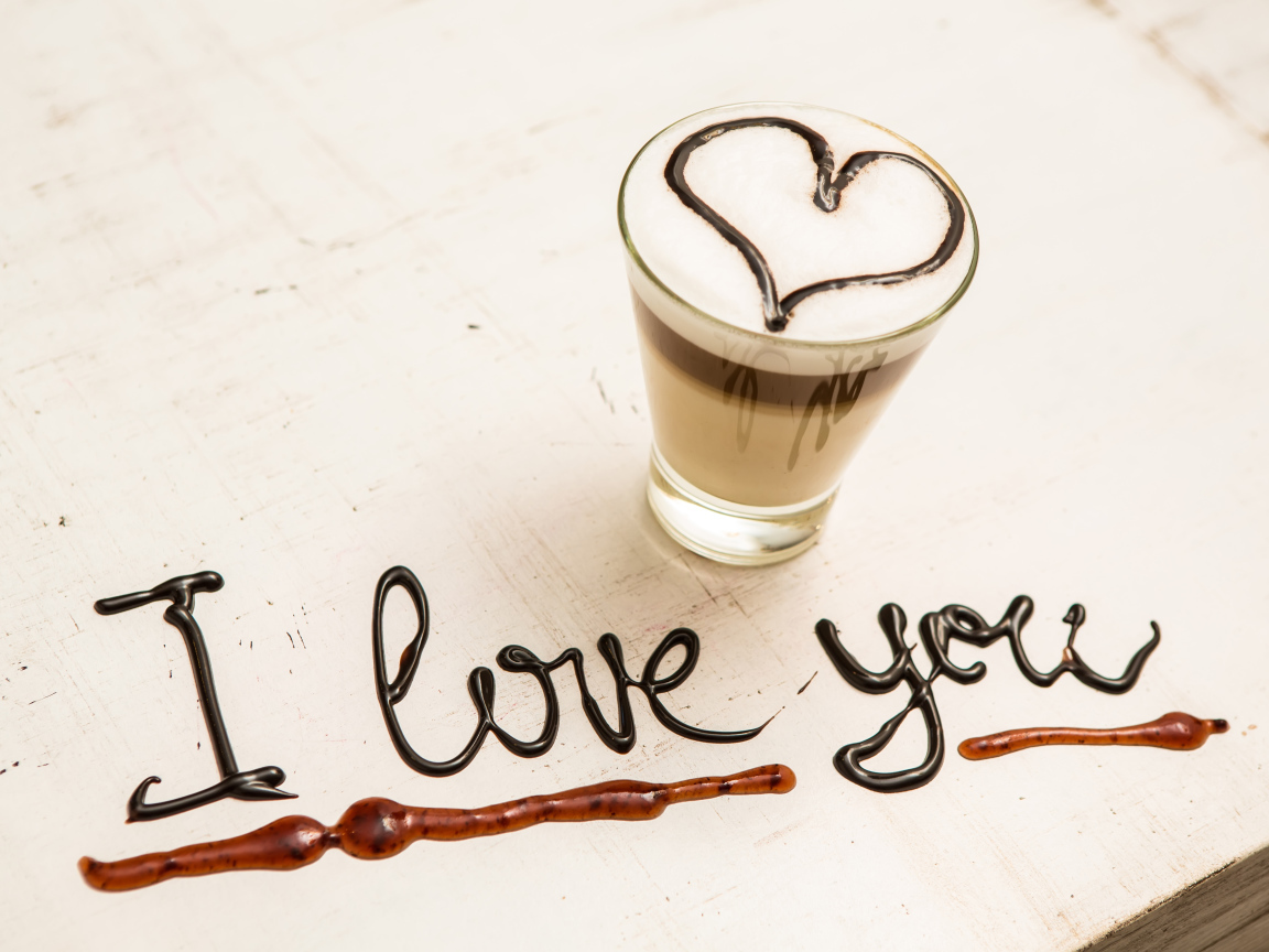 Стакан кофе с сердцем и надпись шоколадом Я тебя люблю  на столе