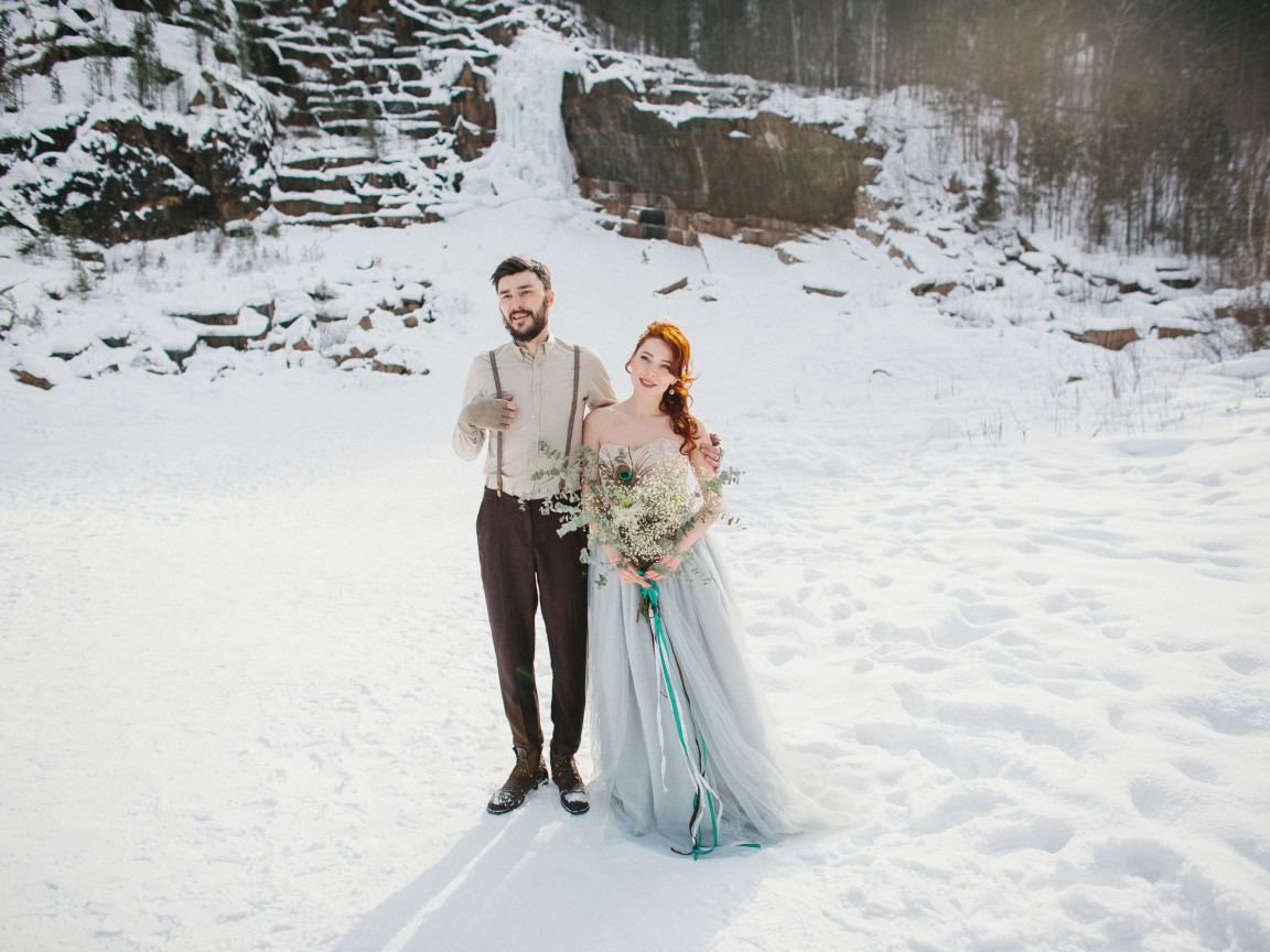 Влюбленная пара молодоженов стоит на снегу