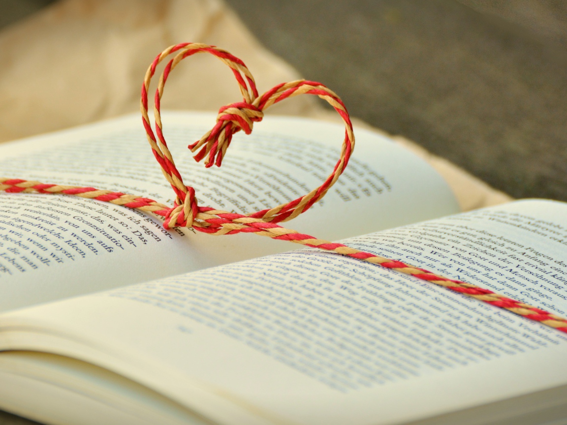 Сердце из веревки лежит на открытой книге