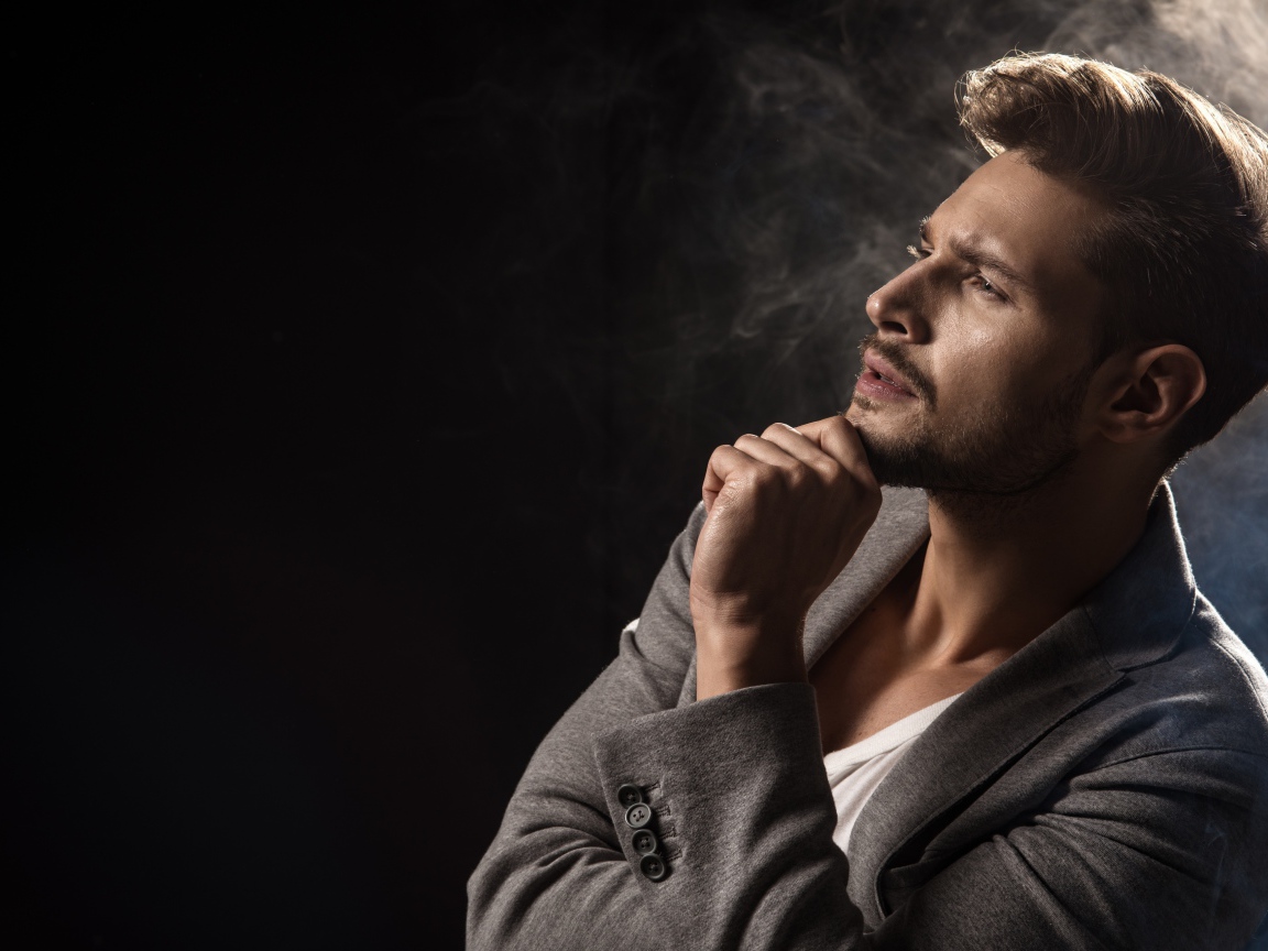 Красивый задумчивый мужчина в сером пиджаке