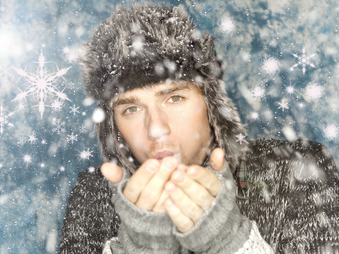 Молодой парень в теплой шапке мерзнет зимой