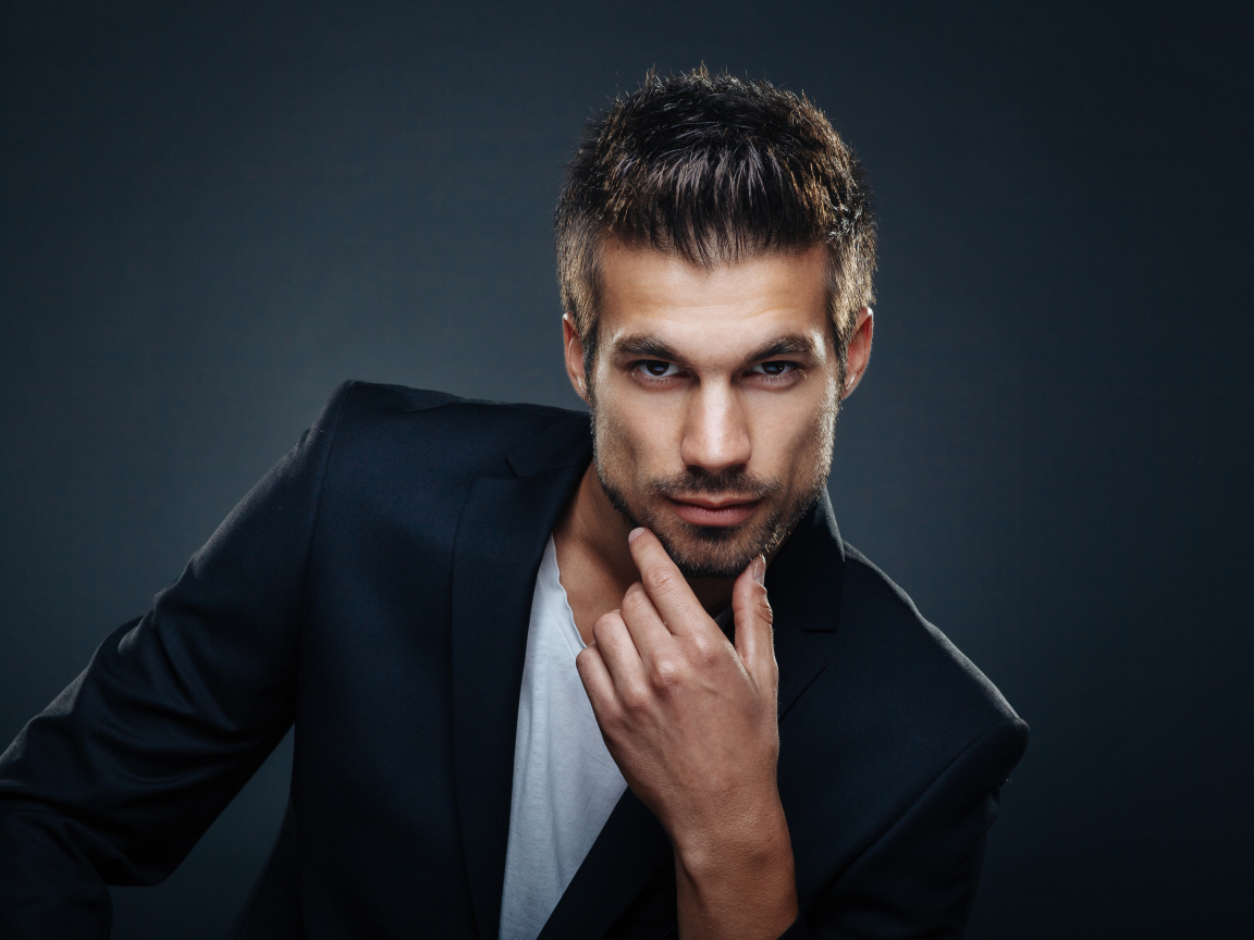 Красивый стильный мужчина в костюме на сером фоне