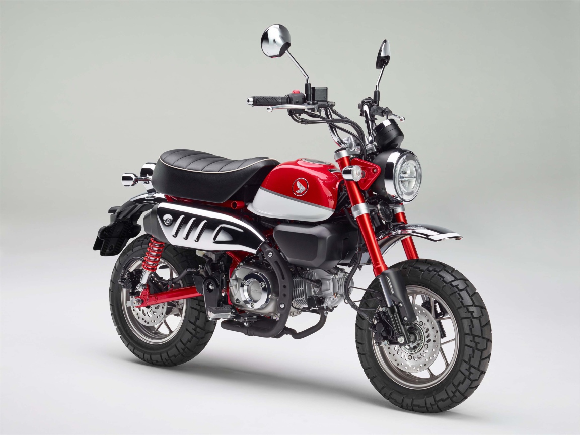 Красный мотоцикл Honda Monkey, 2018 года на сером фоне
