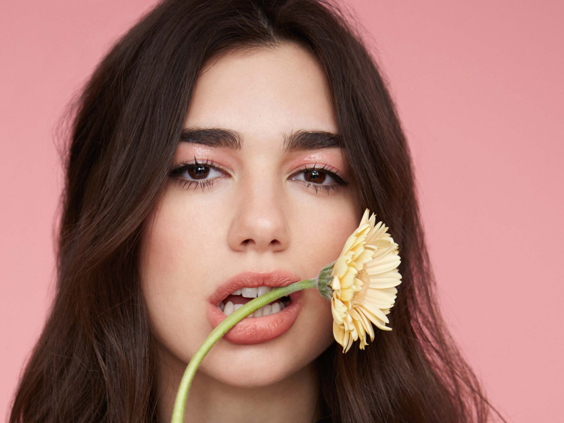 Певица Дуа Липа с цветком герберы во рту