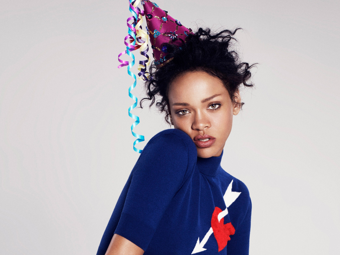 Певица Рианна в праздничном колпаке на сером фоне