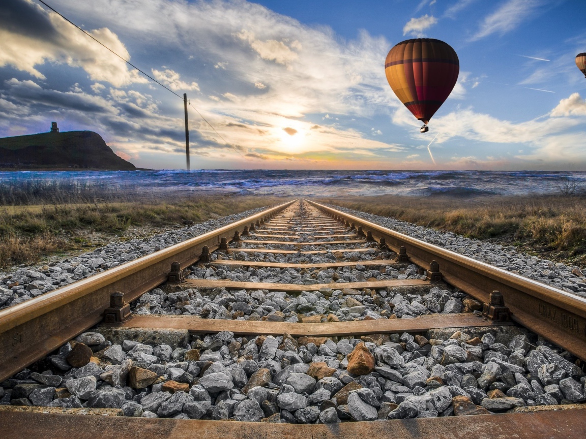 Воздушный шар в красивом голубом небе над железной дорогой