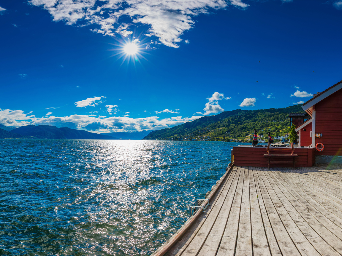 Яркое солнце в голубом небе над водой, Исландия