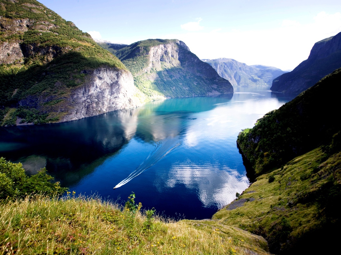 Нерёй-фьорд между горами под красивым голубым небом, Норвегия