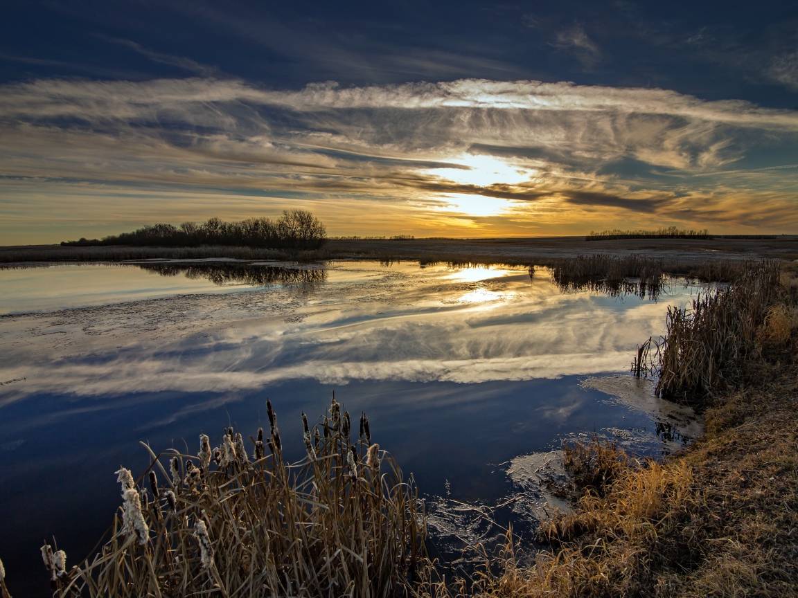 Белые облака отражаются в воде на закате солнца