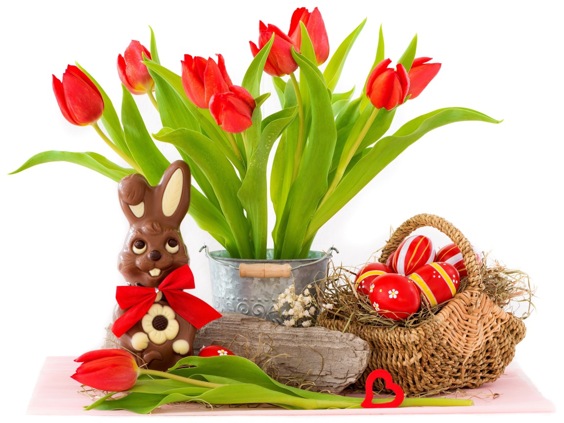 Букет красных тюльпанов на столе с шоколадным кроликом и крашеными яйцами на Пасху