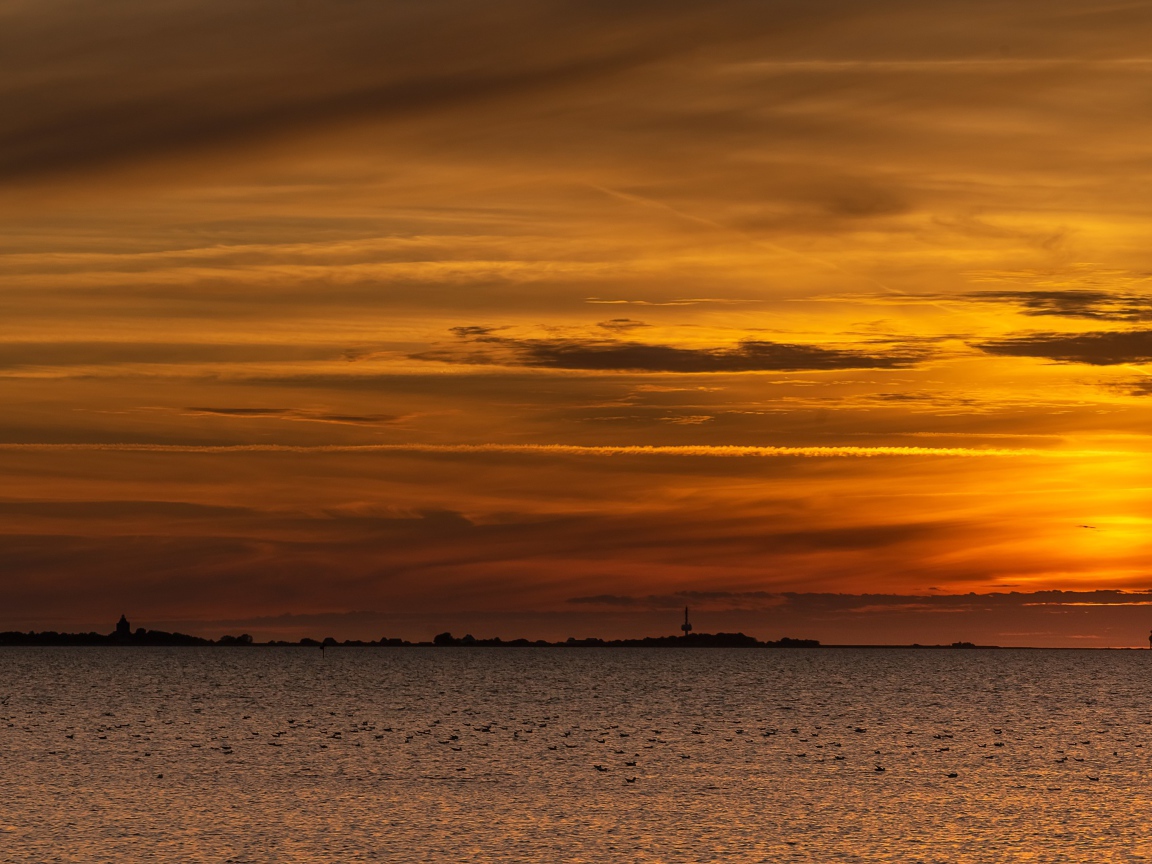 Спокойное море на фоне красивого неба на закате