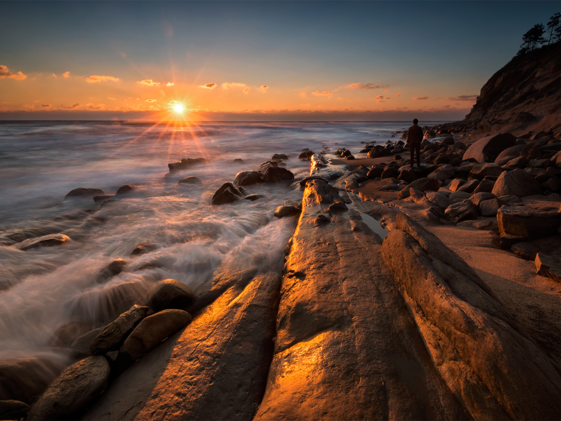 Каменный берег на морском побережье на закате солнца