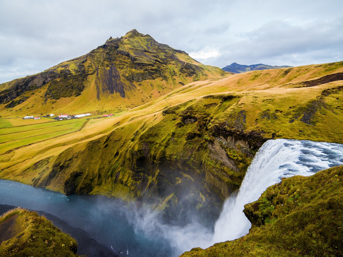 Водопад на фоне покрытых зеленью гор, Исландия