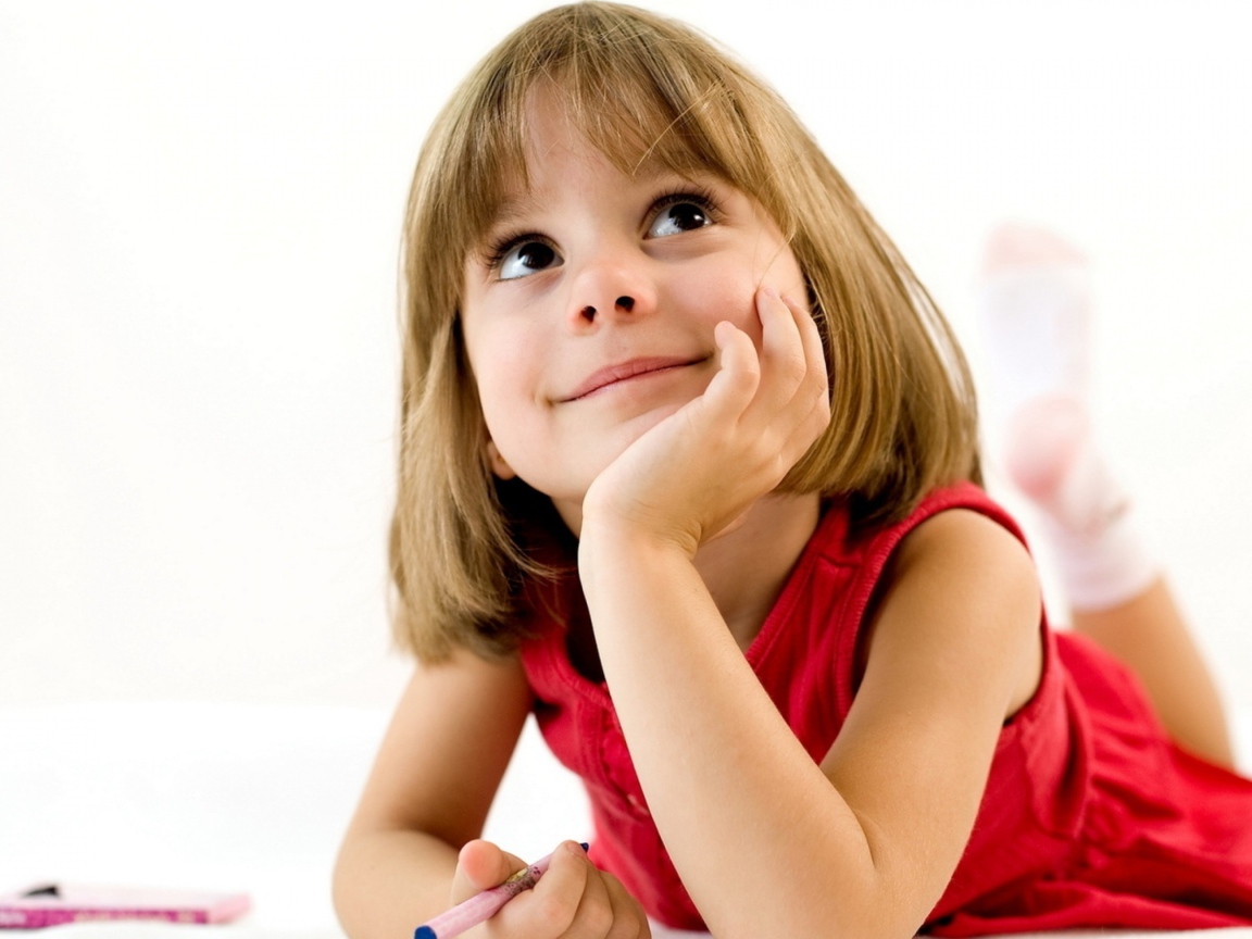 Милая девочка в красном платье рисует