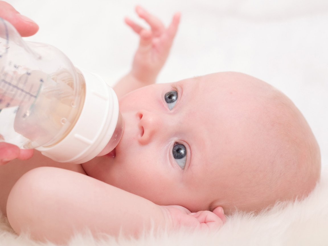 Новорожденного ребенка кормят с бутылки